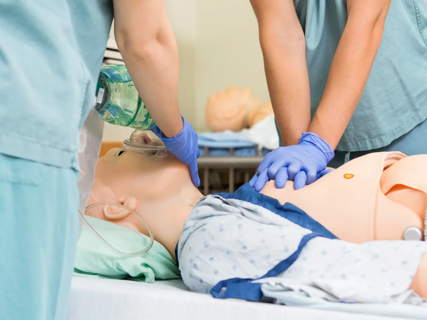 Student practicing CPR chest compressions on a training mannequin
