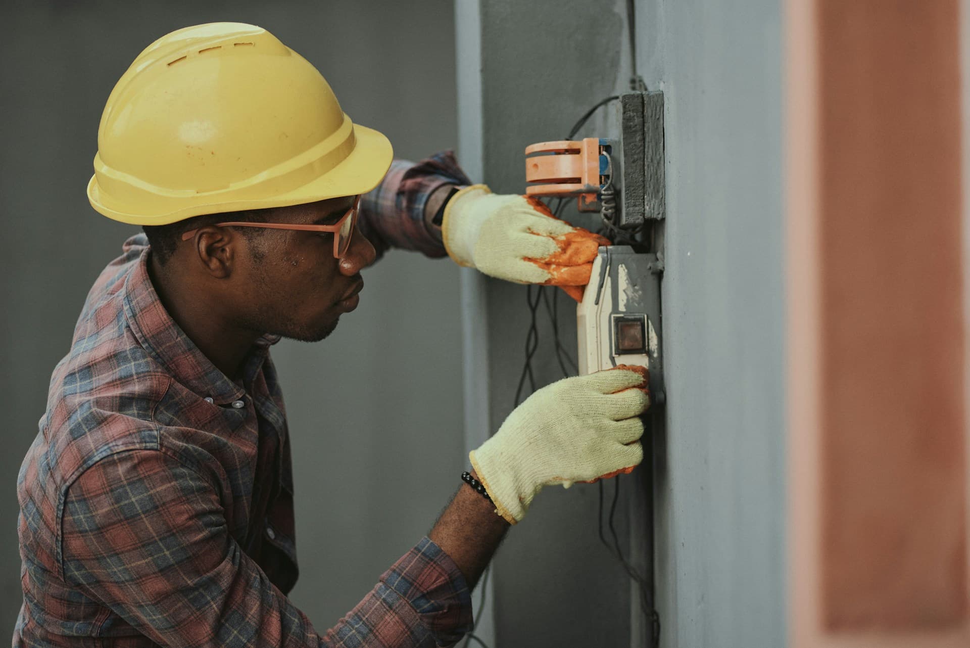 Electrician testing a wall panel with a multimeter