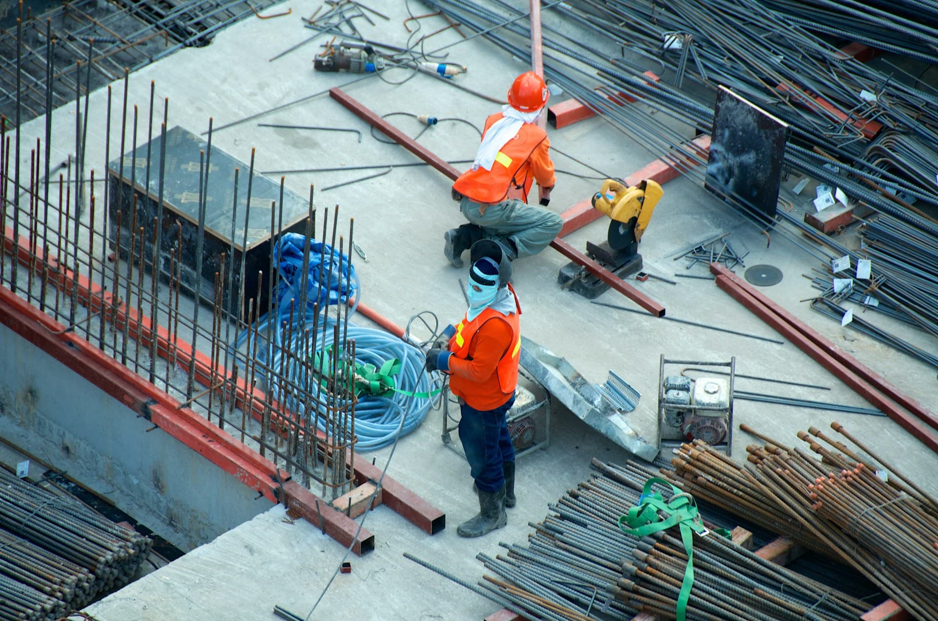 Welder in a protective hood working on a steel construction site